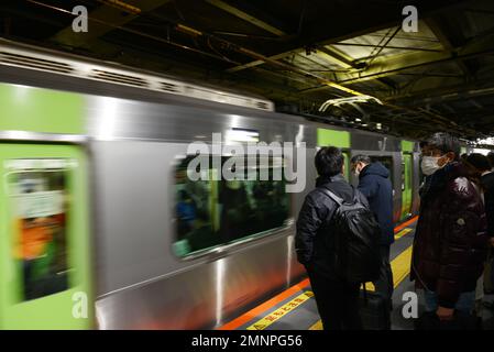 Passagers japonais attendant la ligne JR Yamanote à Tokyo, Japon. Banque D'Images