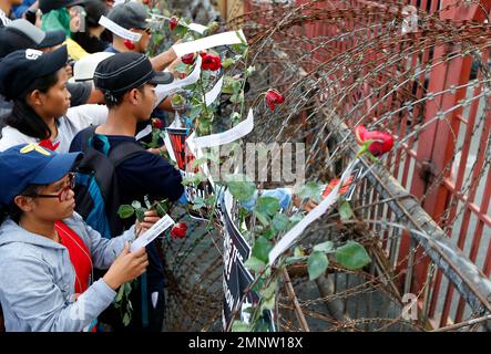Protesters hang placards and flowers on the barbed wire barricade leading to the Presidential Palace during a rally near the Presidential Palace to mark the 32nd anniversary of the 'People Power' revolution Sunday, Feb. 25, 2018 in Manila, Philippines. The protesters scored President Rodrigo Duterte, who skipped the ceremony for the second straight year Sunday, for his 'creeping dictatorship' and are demanding for his ouster. (AP Photo/Bullit Marquez)