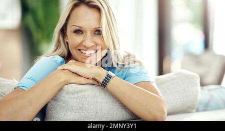 Le bonheur commence à la maison. Portrait court d'une belle femme mûre se détendant sur le canapé à la maison. Banque D'Images