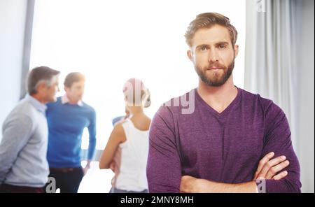 Passons à l'activité, devons-nous. Portrait d'un jeune homme d'affaires avec ses collègues debout à l'arrière-plan. Banque D'Images