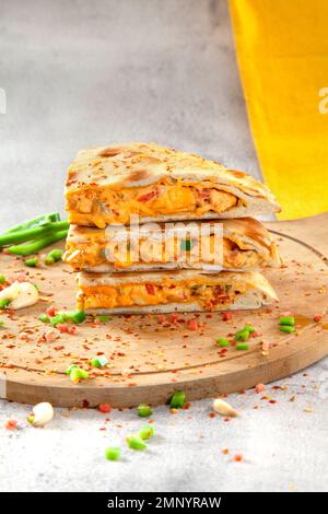 Poulet farci au goût marocain avec épices et légumes sur une planche circulaire en bois. Banque D'Images