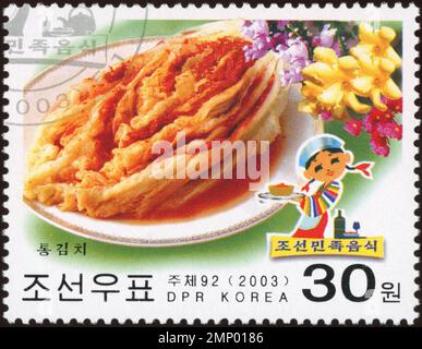 Timbre-poste nord-coréen de 2003 représentant le traditionnel Tong Kimchi et une femme en Hanbok coloré, valeur nominale de 30 won. Banque D'Images