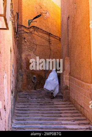 Mozabite femme en haïk blanc dans les rues de Ksar El Atteuf, Afrique du Nord, Ghardaia, Algérie Banque D'Images