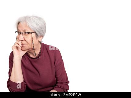 Femme âgée de 70s ans attentionnés et dépressive de race blanche. Problème de vieillesse dame âgée isolée sur blanc, espace de copie. S'ennuyer, souffrant de perte de mémoire. Banque D'Images