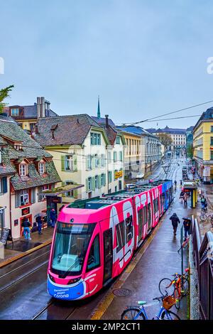 BÂLE, SUISSE - 1 AVRIL 2022 : tramway moderne et coloré sur la rue Kohlenberg dans la vieille ville, sur 1 avril à Bâle, Suisse Banque D'Images