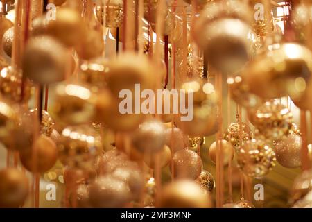 Boules de Noël dorées suspendues ruban suspendu Noël Noël Noël doux mise au point goutte d'eau décoration de fête magique éthérée Banque D'Images