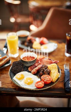 Petit déjeuner brunch sauté pub gastro plein anglais haricots bap tomate noir pudding pomme de terre hash brun œuf brouillés bacon savoureux repas classique Banque D'Images