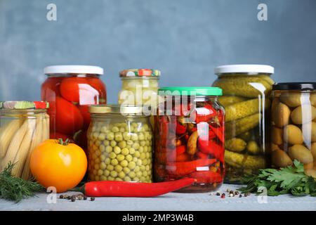 Pots en verre avec différents légumes marinés sur la table Banque D'Images