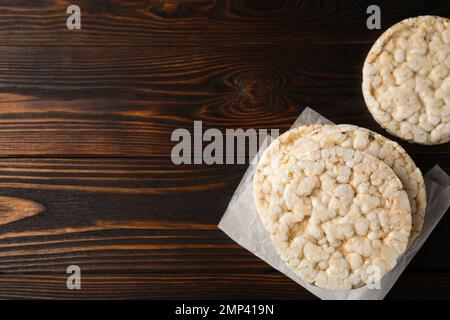 Pile de gâteaux de riz croquants sur table en bois, plat. Espace pour le texte Banque D'Images