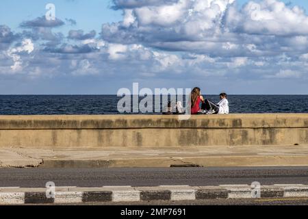 Jeune couple sur le mur de mer, Malecon, Vedado, la Havane, Cuba. Banque D'Images