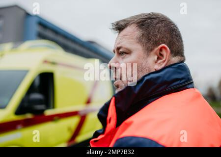 Portrait du secouriste debout près de la voiture d'ambulance. Banque D'Images