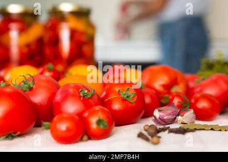 tomates rouges fraîches, épices, assaisonnements et tomates marinées en pots sur la table Banque D'Images