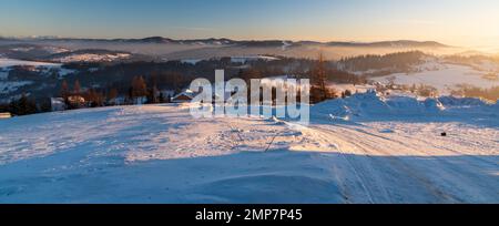 Paysage d'hiver incroyable au-dessus du vilage de Koniakow dans les montagnes de Beskid Slaski en Pologne avec des collines plus proches des montagnes de Beskids et des sommets des Tatras occidentaux Banque D'Images