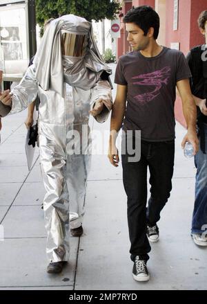 Adrian Grenier, acteur de « l'entourage », marche avec un homme en costume de feu et consulte quelques photos sur un appareil photo numérique pendant que vous filmez dans les rues de Los Angeles. Grenier, qui a récemment été repéré le jour avec la star de télé-réalité Kim Kardashian, aurait signé pour une présentation d'invité sur la série dramatique de l'adolescence '90210'. Los Angeles, Californie. 08/16/10. Banque D'Images