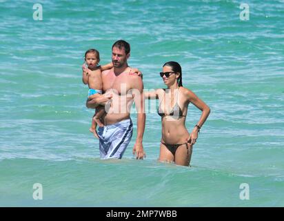 Adriana Lima, la fille Valentina et le mari Marko Jaric s'amusent dans le surf sur Miami Beach, FL, 31st juillet 2011. Banque D'Images