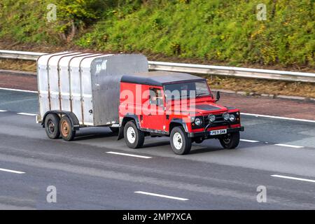 1996 90s années quatre-vingt-dix Red LAND ROVER HT TDI 95 2495cc Diesel traction manuelle d'une remorque agricole à deux roues ; conduite sur l'autoroute M61, Royaume-Uni Banque D'Images