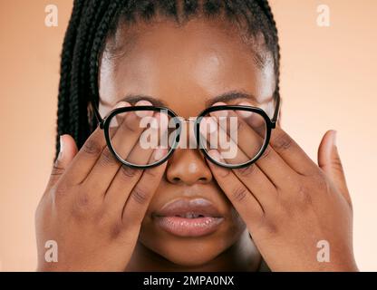 Mains, santé des yeux ou lunettes avec une femme noire en studio sur un fond beige couvrant son visage. Vision, aveugle et couverture avec une femme à l'intérieur de Banque D'Images