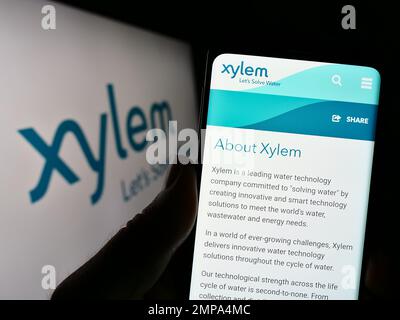 Personne tenant un téléphone portable avec la page Web de la société américaine de technologie de l'eau xylem Inc. À l'écran devant le logo. Concentrez-vous sur le centre de l'écran du téléphone. Banque D'Images