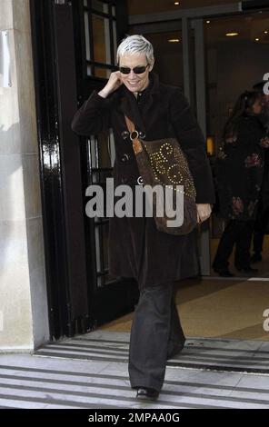 La rocker et ancienne chanteuse Eurythmics Annie Lennox porte un manteau noir avec un pantalon gris et porte un sac à main en daim marron alors qu'elle quitte BBC radio 2. Lennox était tout sourire alors qu'elle bavardait avec les fans sur son chemin. Londres, Royaume-Uni. 3/4/11. Banque D'Images