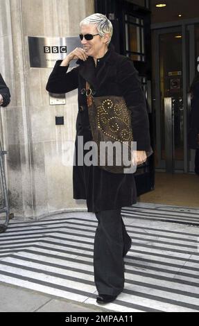 La rocker et ancienne chanteuse Eurythmics Annie Lennox porte un manteau noir avec un pantalon gris et porte un sac à main en daim marron alors qu'elle quitte BBC radio 2. Lennox était tout sourire alors qu'elle bavardait avec les fans sur son chemin. Londres, Royaume-Uni. 3/4/11. Banque D'Images