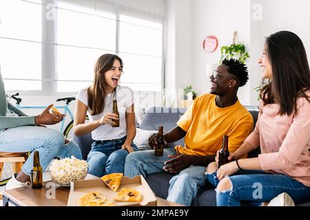 Groupe joyeux de jeunes amis multiraciaux s'amusant ensemble à la maison Banque D'Images