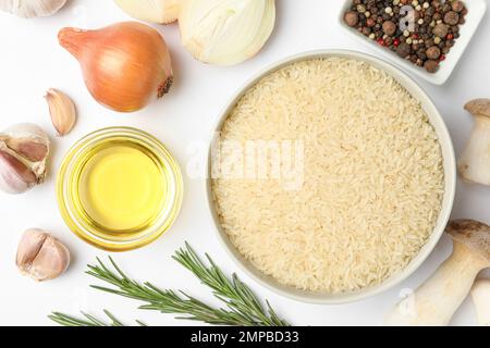 Différents ingrédients sur fond blanc, vue de dessus. Recette de risotto Banque D'Images