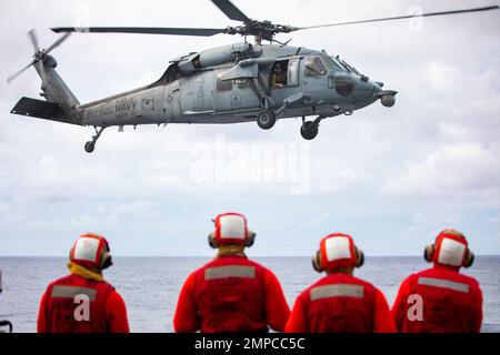 Les marins affectés au destroyer de missile guidé de classe Arleigh Burke USS Ramage (DDG 61) regardent comme un hélicoptère MH-60s Sea Hawk, attaché aux “Tridents” de l’Escadron de combat de la mer (HSC) 9, décollent du pont de vol pendant les opérations de vol dans le cadre du groupe d’impact des transporteurs Gerald R. Ford, 12 octobre 2022. Le premier porte-avions de sa catégorie USS Gerald R. Ford (CVN 78) est en cours de déploiement inaugural, menant des entraînements et des opérations aux côtés des alliés et des partenaires de l'OTAN afin d'améliorer l'intégration pour les opérations futures et de faire la démonstration des États-Unis L’engagement de la Marine en faveur d’un a pacifique et stable Banque D'Images