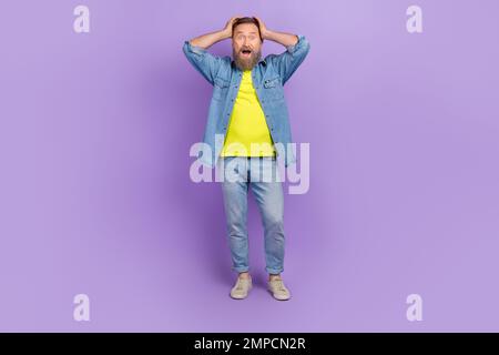 Pleine photo de Nice homme retraité mains tête terrifiée choc réaction porter tendance jeans ensemble isolé sur fond jaune couleur Banque D'Images