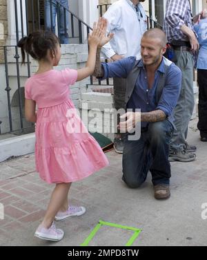 David Beckham donne un hi-cinq à une jeune fille pendant le tournage d'une annonce pour Sharpie. Les annonces montrent Beckham en utilisant un Sharpie pour autographe une variété d'objets inhabituels pour les fans. La fille sera dans l'annonce et les annonces imprimées et TV seront lancées dans le monde entier en juillet, Los Angeles, CA, 5/8/08. Banque D'Images