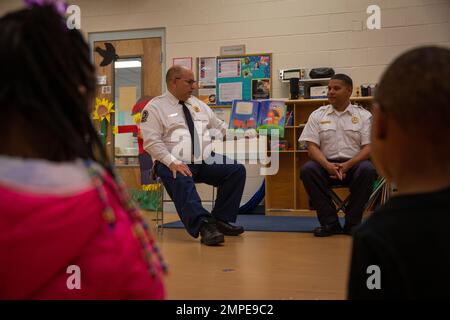 Lawrence Shinn, chef adjoint, à gauche, et Leon Hughes, spécialiste de la protection contre les incendies, Les deux avec la base de corps de Marine Quantico Fire and Emergency Services, lire des livres aux enfants au Centre de développement de l'enfant sur la base de corps de Marine Quantico, Virginie, 13 octobre 2022. Le MCB Quantico Fire and Emergency Services a favorisé les relations communautaires tout en faisant la promotion de la sécurité-incendie pour les jeunes générations. Banque D'Images