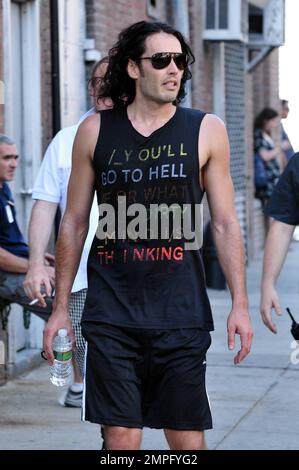 Russell Brand porte un équipement d'entraînement, y compris une chemise sans manches qui dit « vous allez faire l'enfer pour ce que votre esprit sale est en train de penser », alors qu'il se dirige vers sa remorque pour changer. Plus tard, il émerge dans une combinaison de bronzage, une chemise noire et des tongs sur le set de son nouveau film, une reframe du succès de 1981 'Arthur'. Dans le film, il joue le rôle d'Arthur, joué à l'origine par Dudley Moore. Brand est rejoint dans le film par Helen Mirren, qui joue son maître d'hôtel, un rôle qui a remporté à l'origine Sir John Gielgud son unique Oscar. Mirren a également été repéré sur l'ensemble portant un chapeau bleu à pois, des lunettes de soleil, un haut blanc et un ski plissé Banque D'Images