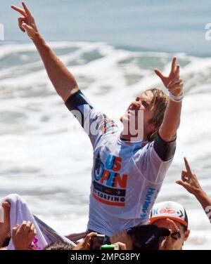 Brett Simpson, originaire de Huntington Beach, affiche le signe de la paix alors qu'il est porté sur les épaules de ses fans depuis l'océan après avoir remporté l'US Surfing Open pour la deuxième fois consécutive, laissant Jordy Smith d'Afrique du Sud dans son sillage. Huntington Beach, Californie. 08/08/10. Banque D'Images