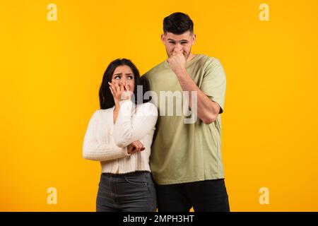Triste insatisfait jeune femme arabe et gars dans le nez de couverture avec les doigts, souffrent de mauvaise odeur Banque D'Images