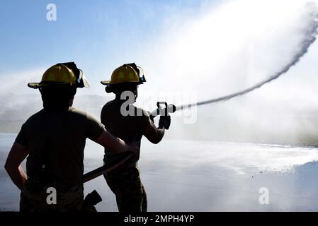 Le sergent d'état-major Logan Sexton (à gauche) et les pompiers de classe 1st d'Airman Steven Perry, tous deux pompiers de l'escadron du génie civil 117th, utilisent des tuyaux d'attaque de 1 et 3/4 pouces le 16 octobre 2022 sur la ligne de vol à la base de la Garde nationale interarmées de Sumpter-Smith, en Alabama. Les pompiers étaient en service pendant qu'un autre pompier contrôlait l'eau pour l'essai de certification de l'opérateur de leur appareil. Banque D'Images