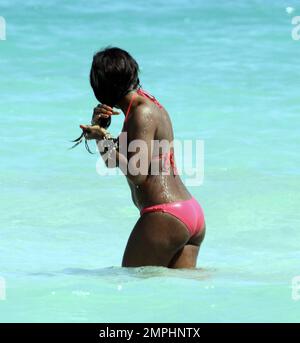 Alexandra Burke porte un bikini couleur pêche à la plage comme elle aime un autre jour au soleil. Tout en faisant une promenade sur la plage dans une robe longue rayée tendance Burke s'est arrêté pour ramasser des coquillages avant de prendre un plongeon dans l'eau de refroidissement. Plus tard, la chanteuse a montré ses multiples bracelets perlés comme elle a texté sur son unique téléphone cellulaire clouté. Miami Beach, Floride. 3/7/11 Banque D'Images