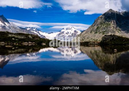 Sommets enneigés des montagnes Jungfrau, Spinx, Mönch et Trugberg au bout du glacier d'Aletsch se reflétant dans un petit lac de montagne. Banque D'Images