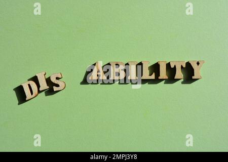 Handicap, capacité, mot en lettres de l'alphabet en bois isolées sur fond vert Banque D'Images