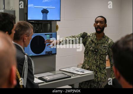 GRANDS LACS, Illinois (28 octobre 2022) – instructeur de classe Asa Kinsey (Aegis) 2nd, technicien en contrôle d'incendie, en poste au Commandement de l'entraînement des systèmes de combat de surface des Grands Lacs (SCSTC GL), explique l'entraîneur partiel de radar T1 à 18 attachés diplomatiques lors d'une visite du campus. Le formateur partiel de radar T1 enseigne aux marins les principes de fonctionnement de base nécessaires pour dépanner l'équipement et effectuer les réparations nécessaires. Le SCSTC Great Lakes forme plus de 10 000 marins chaque année sur 22 cours d'enseignement dans quatre écoles. Le SCSTC Grands Lacs est responsable de la supervision 24 heures, chef Banque D'Images