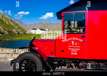 Une fourgonnette rouge d'époque de la distillerie Saint Bernard garée au sommet de la Great St. Col Bernard. Banque D'Images