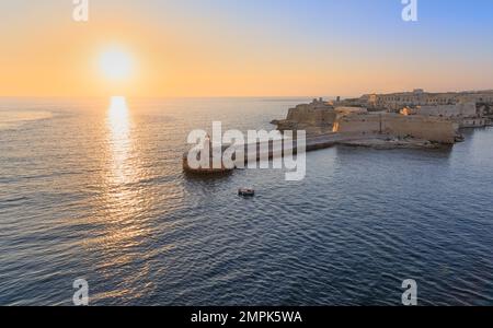 Vue au lever du soleil sur le phare de la jetée dans le port de la Valette sur l'île de Malte. Banque D'Images