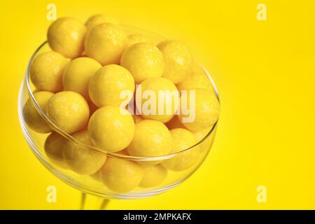 Gommes à mâcher au citron savoureuses en verre sur fond jaune Banque D'Images