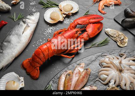 Poisson frais et différents fruits de mer sur table noire Banque D'Images