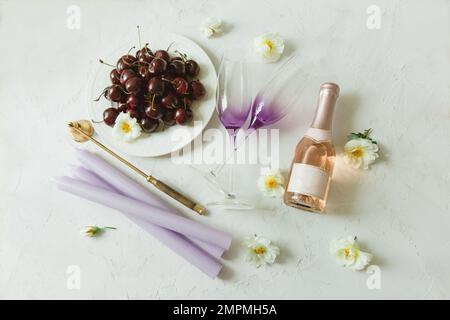 Cerises sur une assiette avec vigne et verres Banque D'Images