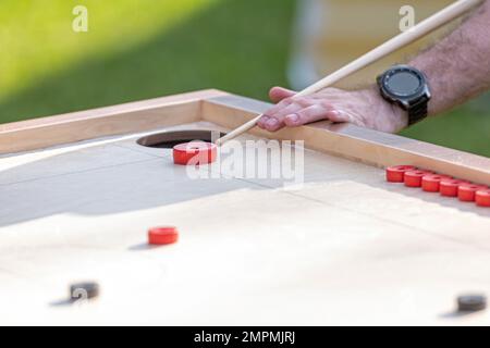 Hommes jouant au jeu de Novus. Novuss est un sport national en Lettonie semblable au billard de poche ou à la piscine. Banque D'Images