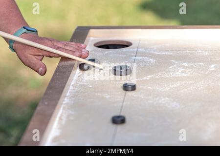 Hommes jouant au jeu de Novus. Novuss est un sport national en Lettonie semblable au billard de poche ou à la piscine. Banque D'Images