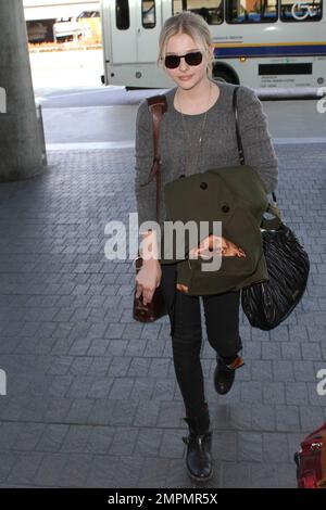 Oscar nominé film, 'Hugo,' actrice Chloe Grace Moretz dans un chandail gris, pantalon noir, bottes noires et portant un manteau vert a été vu au départ de l'aéroport international de Los Angeles avant le week-end des Oscar. Il a été récemment rapporté que Moretz, 15 ans, a été nommée gagnante cette année du prix « Max Mara » du visage du futur féminin dans le film, qu'elle sera honorée lors des prix « Women in film Crystal Lucy Awards » en juin. Chloe doit se rendre à Milan, en Italie, le week-end pour le spectacle de mode Sportmax, comme indiqué. Los Angeles, Californie. 23rd février 2012. Banque D'Images