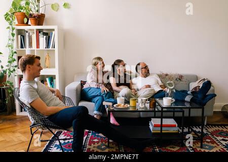 Famille passant du temps libre ensemble à regarder un film dans le salon à la maison Banque D'Images