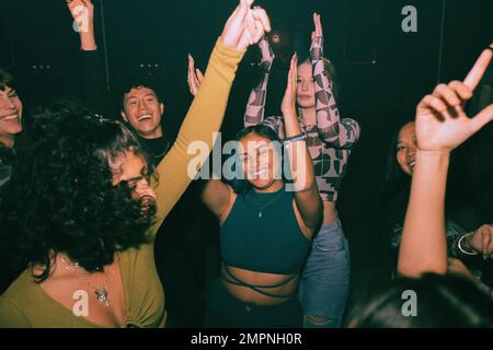 De jeunes amis joyeux dansant et se faisant plaisir à la discothèque Banque D'Images