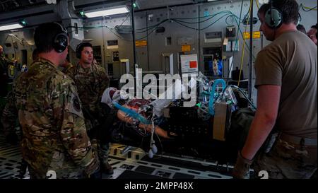 Un groupe d'aviateurs charge une fausse victime lors d'un exercice d'entraînement conjoint à bord d'un C-17 Globemaster III à la base aérienne Wright-Patterson, Ohio, le 9 novembre 2022. L'escadron d'évacuation aéromédicale 445th et l'équipe de transport aérien de soins critiques du Groupe médical 88th ont mené la formation, simulant un environnement de vol en direct où les aviateurs apprennent à se préparer à des défis tels que la turbulence, les changements de température et la pression de l'air, car ils s'occupent de patients gravement malades. Banque D'Images