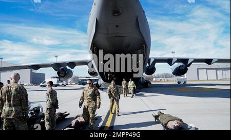 Un groupe d'aviateurs chargent de l'équipement et des blessés fictifs dans un C-17 Globemaster III lors d'un exercice d'entraînement conjoint à la base aérienne Wright-Patterson, Ohio, le 9 novembre 2022. L'escadron d'évacuation aéromédicale 445th et l'équipe de transport aérien de soins critiques du Groupe médical 88th ont mené la formation, simulant un environnement de vol en direct où les aviateurs apprennent à se préparer à des défis tels que la turbulence, les changements de température et la pression de l'air, car ils s'occupent de patients gravement malades. Banque D'Images